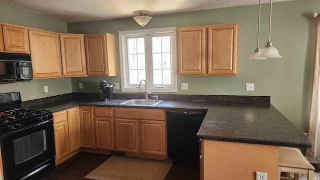 kitchen with a peninsula, dark countertops, a sink, and black appliances