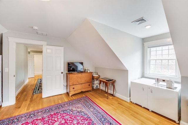 bonus room with vaulted ceiling, visible vents, and wood finished floors