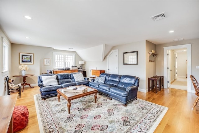 living room with light wood-style floors, visible vents, and recessed lighting