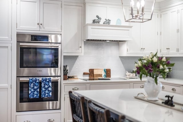 kitchen featuring double oven, light countertops, and white cabinetry