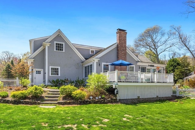 back of property featuring a yard, fence, a chimney, and a deck