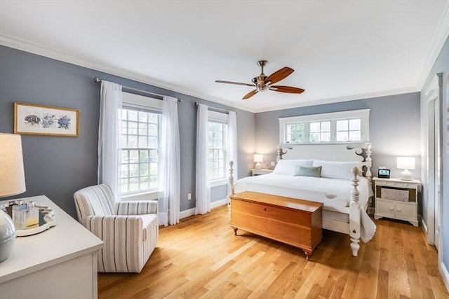 bedroom with light wood-style floors, crown molding, and multiple windows