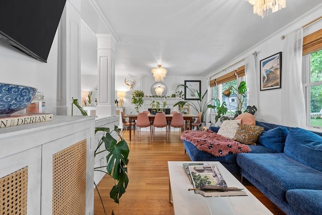 2313 Washington St, Holliston, MA 01746 - living area with ornate columns, light wood-type flooring, a chandelier, and ornamental molding