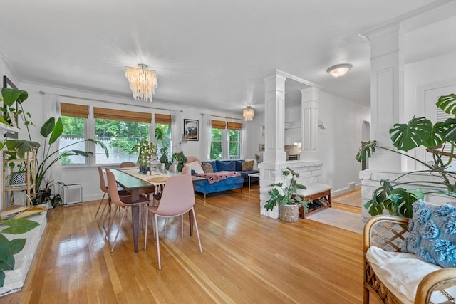 2313 Washington St, Holliston, MA 01746 - dining space featuring decorative columns, light wood-style flooring, ornamental molding, a chandelier, and baseboards