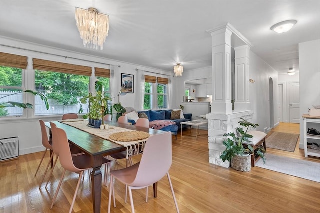 2313 Washington St, Holliston, MA 01746 - dining space with light wood-style floors, decorative columns, a chandelier, baseboards, and crown molding