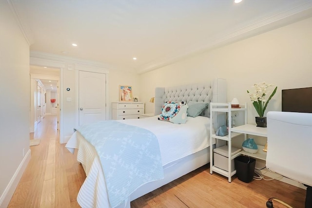 bedroom with ornamental molding and light hardwood / wood-style flooring