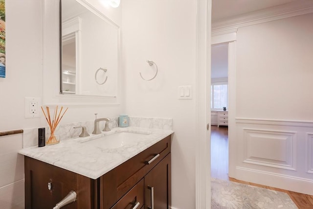 bathroom with vanity, hardwood / wood-style flooring, and ornamental molding