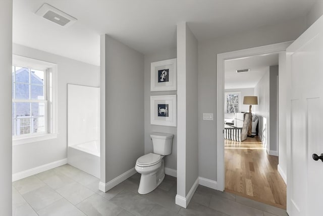 bathroom with tile patterned floors, toilet, and a bathtub