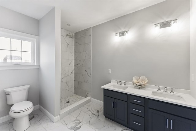 bathroom featuring a tile shower, vanity, and toilet