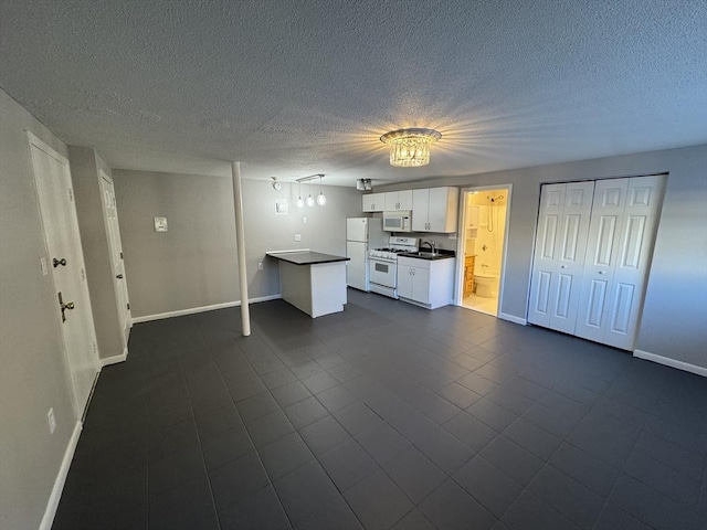 basement with white refrigerator, sink, and a textured ceiling