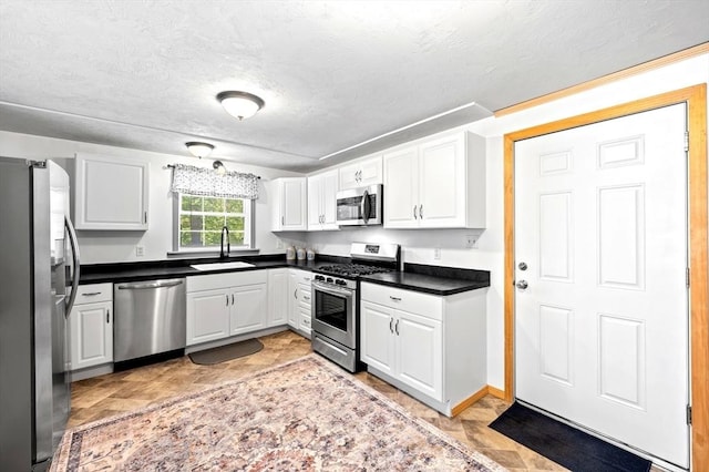 8 Intervale Rd, Rutland, MA 01543 - kitchen with appliances with stainless steel finishes, dark countertops, a sink, white cabinetry, and a textured ceiling