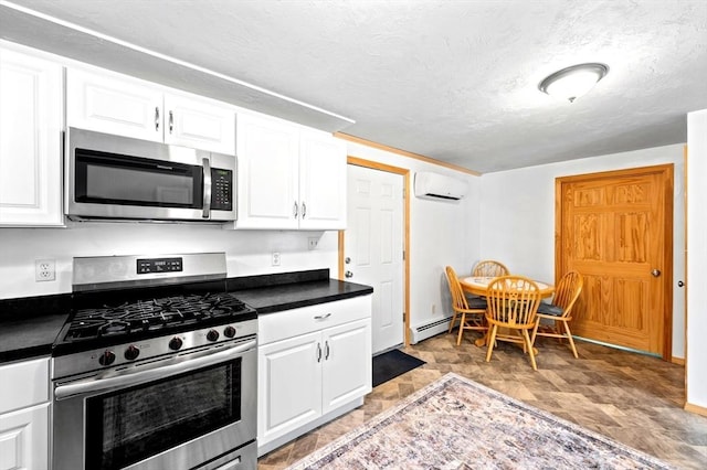 8 Intervale Rd, Rutland, MA 01543 - kitchen with appliances with stainless steel finishes, a baseboard radiator, dark countertops, an AC wall unit, and a textured ceiling