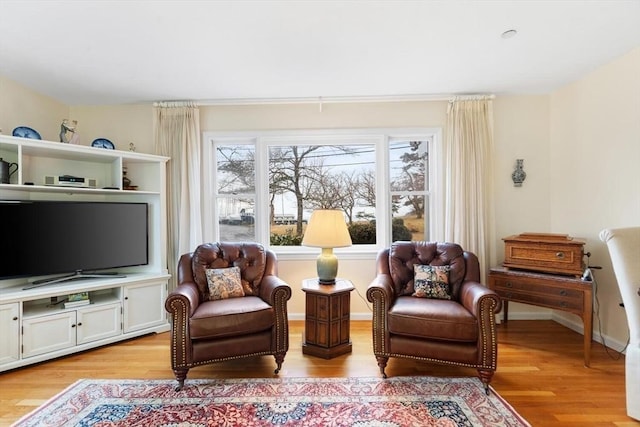 sitting room with baseboards and light wood-style floors