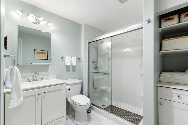 full bath featuring toilet, a stall shower, vanity, and tile patterned floors