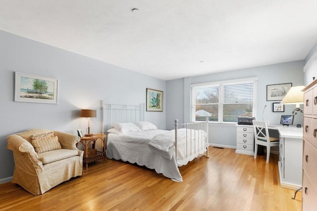 bedroom with light wood-type flooring and baseboards