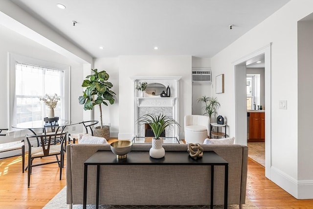 living area featuring light wood-style floors, plenty of natural light, a fireplace, and recessed lighting