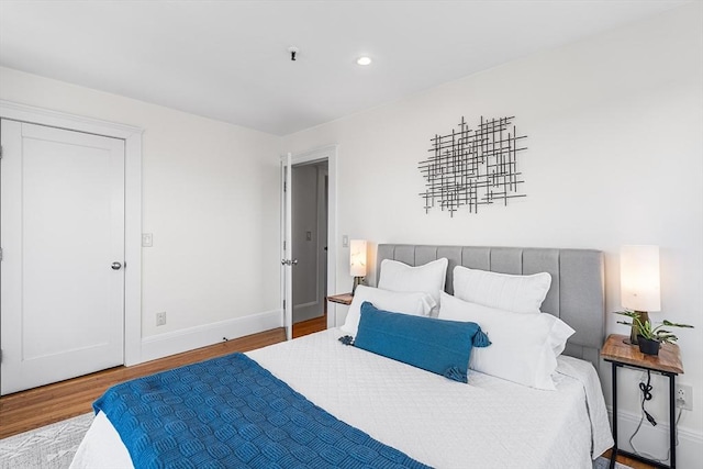 bedroom featuring baseboards, recessed lighting, and wood finished floors