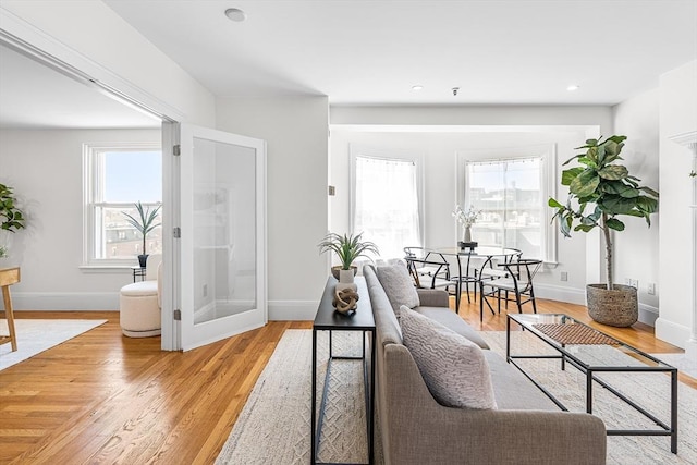 living area with light wood-style floors, recessed lighting, and baseboards