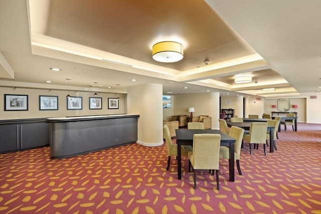 dining area with a tray ceiling and carpet flooring