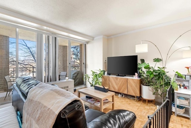 living room with a textured ceiling, ornamental molding, floor to ceiling windows, and light parquet floors