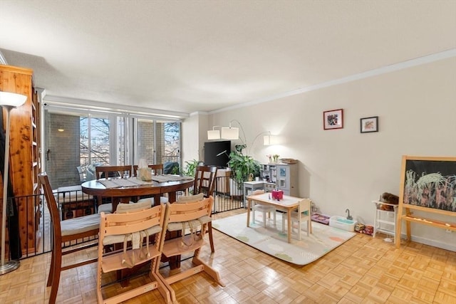 dining area with crown molding and light parquet floors