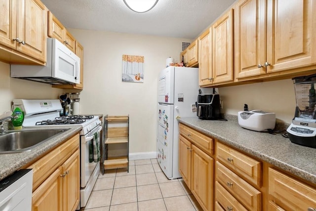 kitchen featuring light tile patterned floors, white appliances, and light brown cabinets