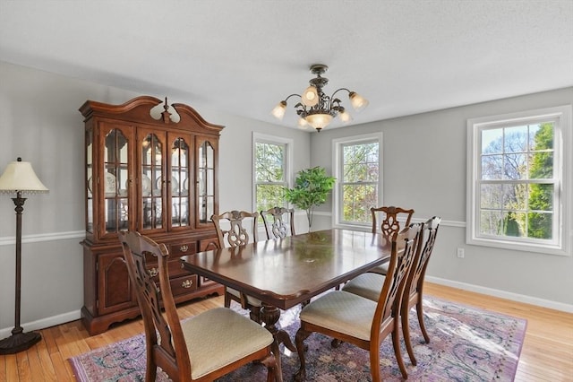dining room featuring baseboards, a chandelier, and light wood-style flooring