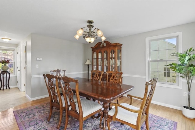 dining room featuring an inviting chandelier, light wood-style floors, and baseboards
