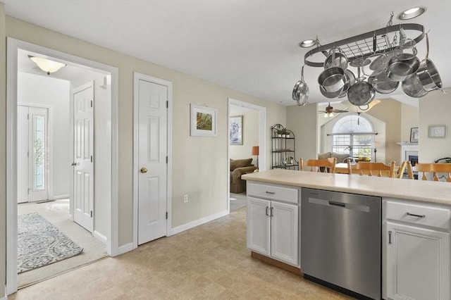 kitchen with a ceiling fan, dishwasher, light countertops, light floors, and white cabinetry