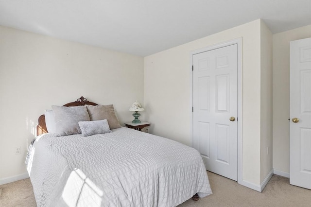 bedroom featuring light colored carpet and baseboards