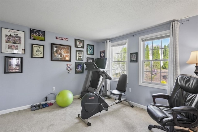 exercise room with carpet floors, a textured ceiling, and baseboards