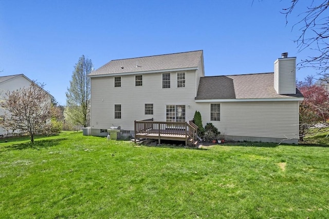rear view of property featuring a chimney, central air condition unit, a yard, and a deck