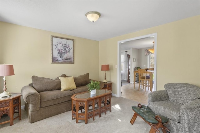 living room featuring baseboards and light carpet
