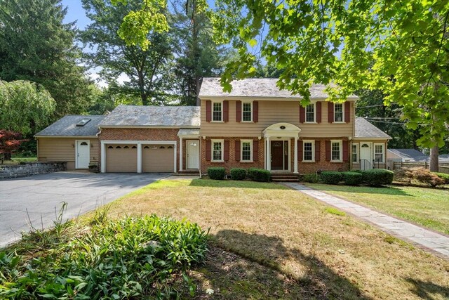 colonial home with a garage and a front yard