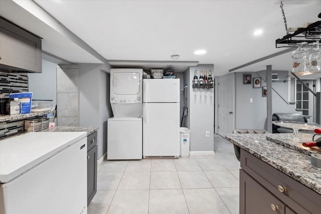 kitchen with refrigerator, tasteful backsplash, white fridge, stacked washer and clothes dryer, and light tile patterned floors