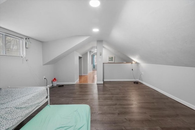 bedroom featuring multiple windows, lofted ceiling, and dark hardwood / wood-style floors