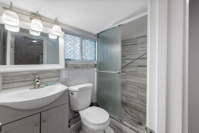 bathroom with vanity, a shower with door, and toilet