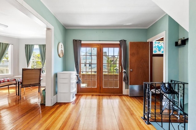 doorway to outside featuring crown molding, wood-type flooring, and french doors