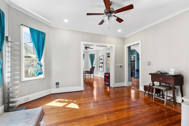 interior space featuring crown molding, ceiling fan, plenty of natural light, wood finished floors, and visible vents