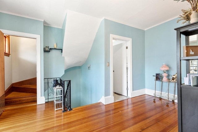 additional living space featuring baseboards and wood finished floors