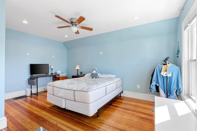 bedroom featuring a ceiling fan, baseboards, wood finished floors, lofted ceiling, and visible vents