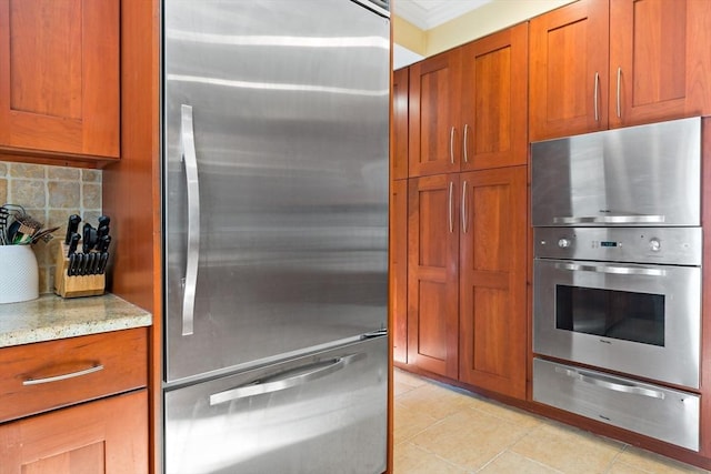 218 Pine St, Rehoboth, MA 02769 - kitchen with stainless steel appliances, a warming drawer, brown cabinets, light stone counters, and crown molding