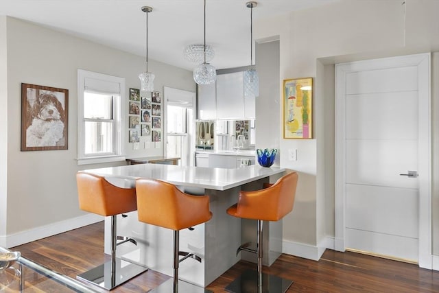 416 Commonwealth Ave Unit 317, Boston, MA 02215 - kitchen with a kitchen bar, light countertops, a peninsula, dark wood-style floors, and white cabinetry