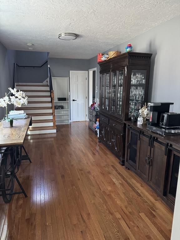 interior space with stairs, hardwood / wood-style floors, and a textured ceiling