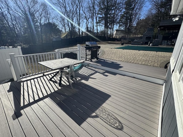 deck featuring exterior fireplace and a fenced backyard