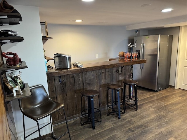 bar with a dry bar, recessed lighting, wood finished floors, and freestanding refrigerator