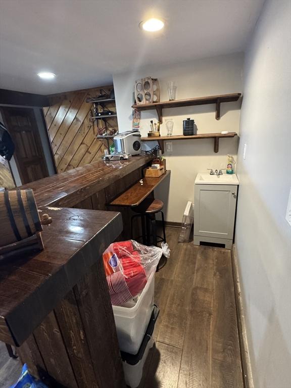 bar featuring a sink, recessed lighting, and wood finished floors