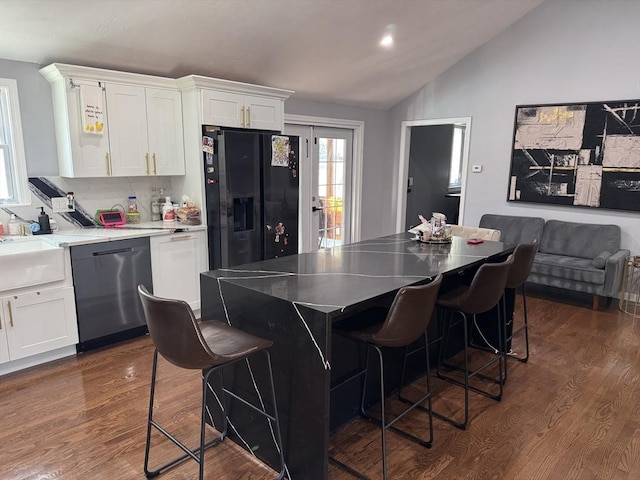 kitchen featuring stainless steel dishwasher, dark wood finished floors, black fridge, and white cabinetry