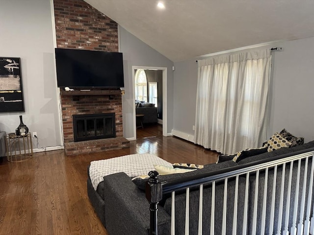 living room with a brick fireplace, wood finished floors, baseboards, and high vaulted ceiling