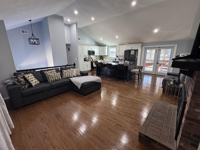 living room with visible vents, high vaulted ceiling, dark wood-style floors, recessed lighting, and french doors